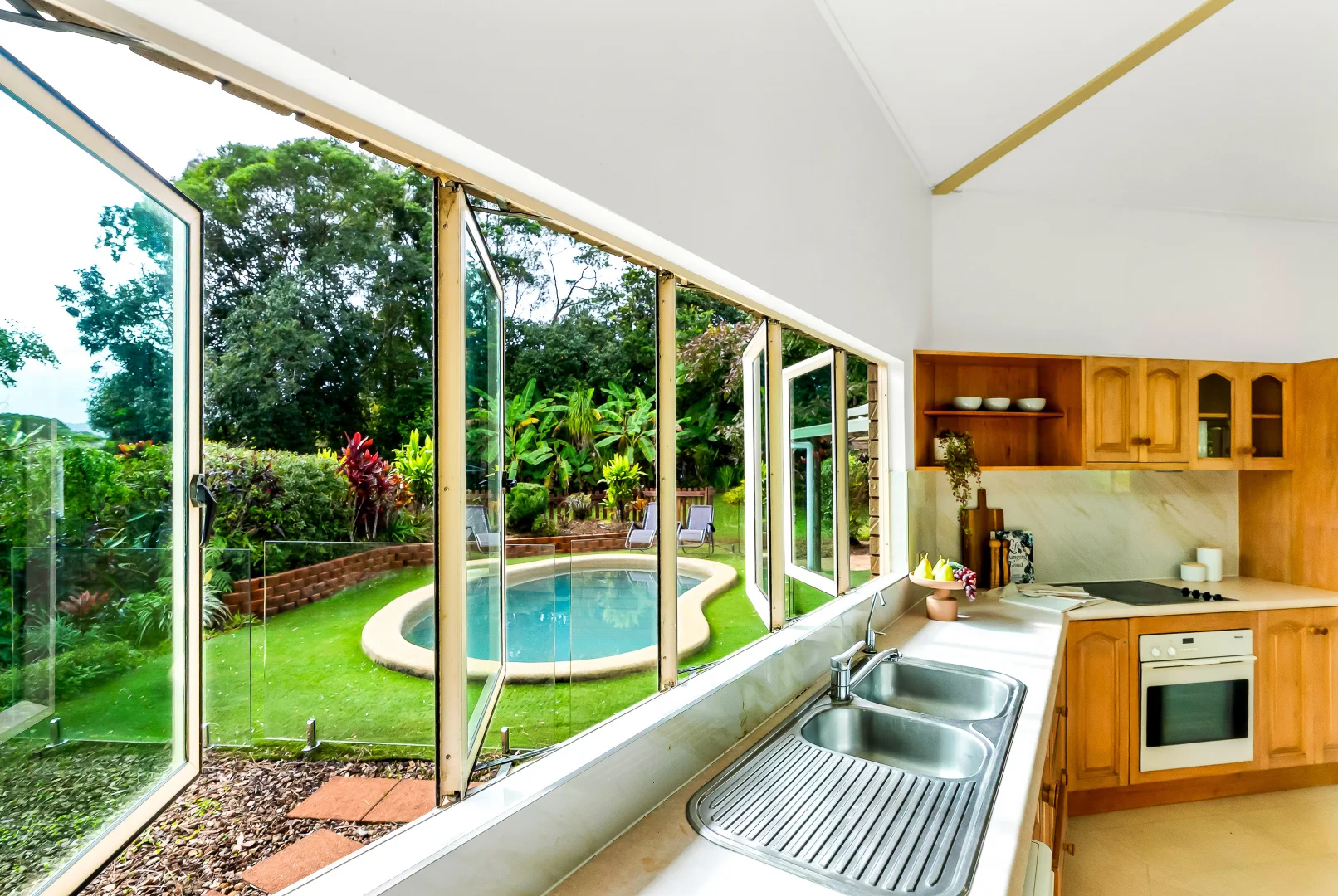 View from the kitchen windows toward the garden and pool